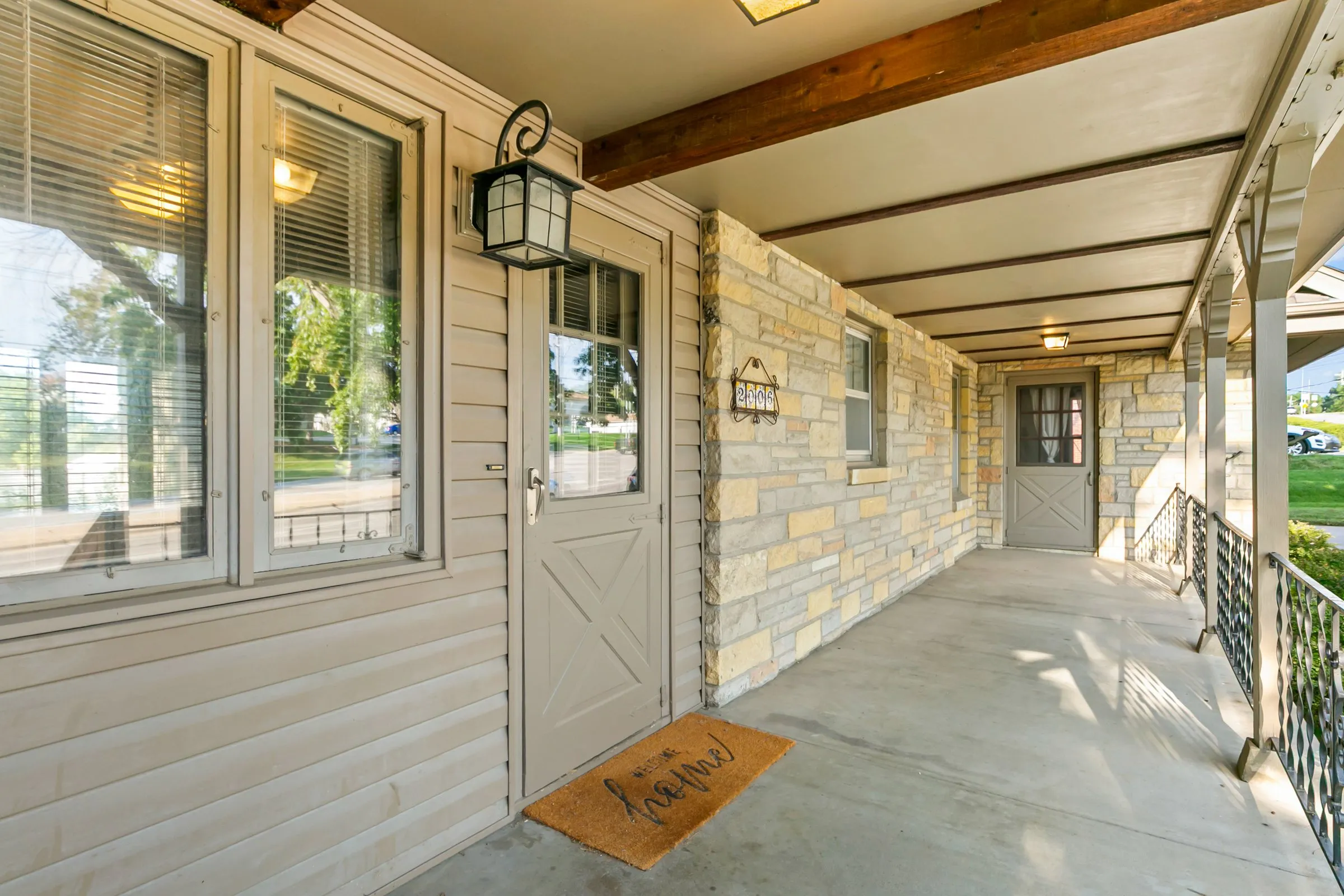 Covered front porch with lantern and stone wall