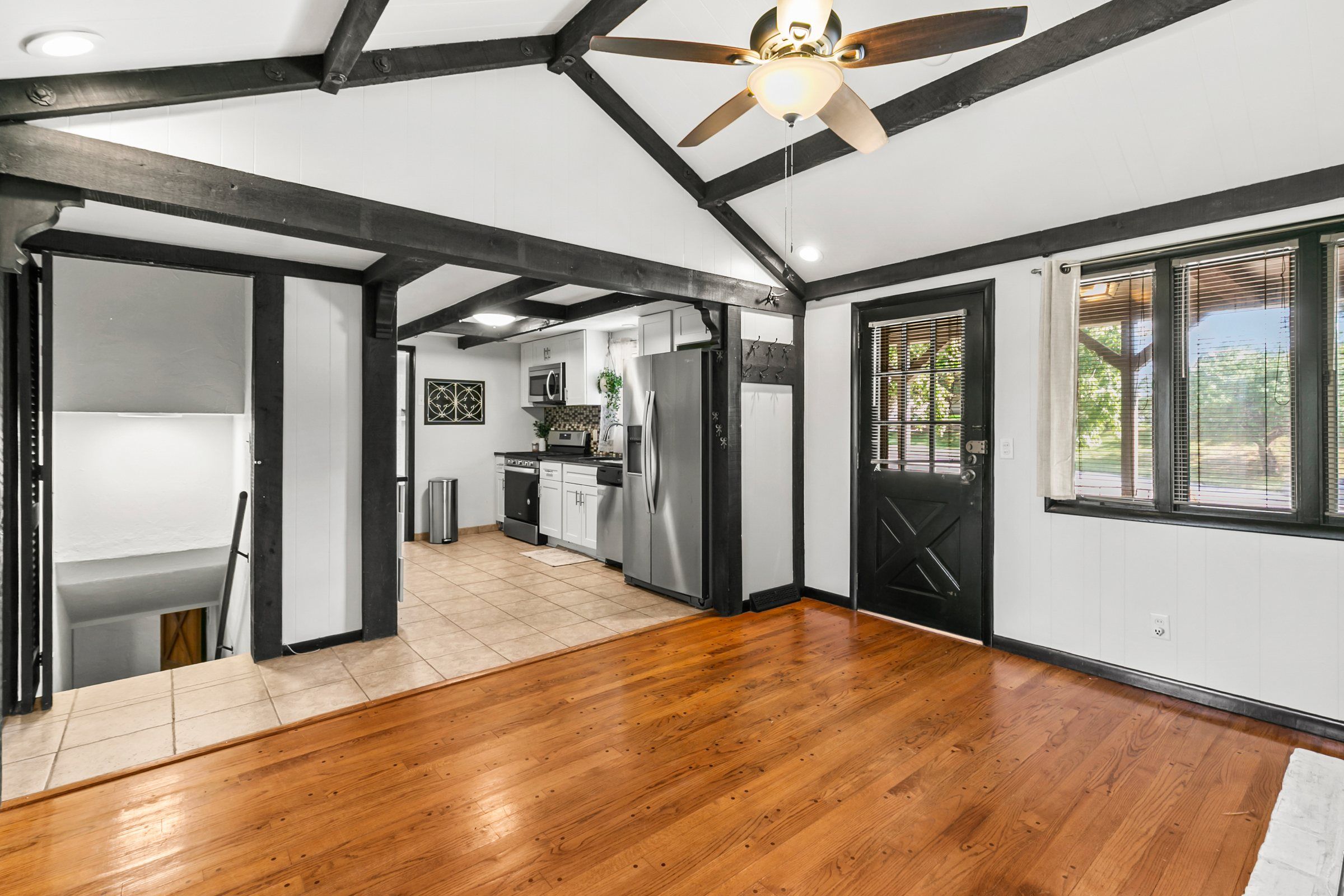 Living room opening to a white kitchen