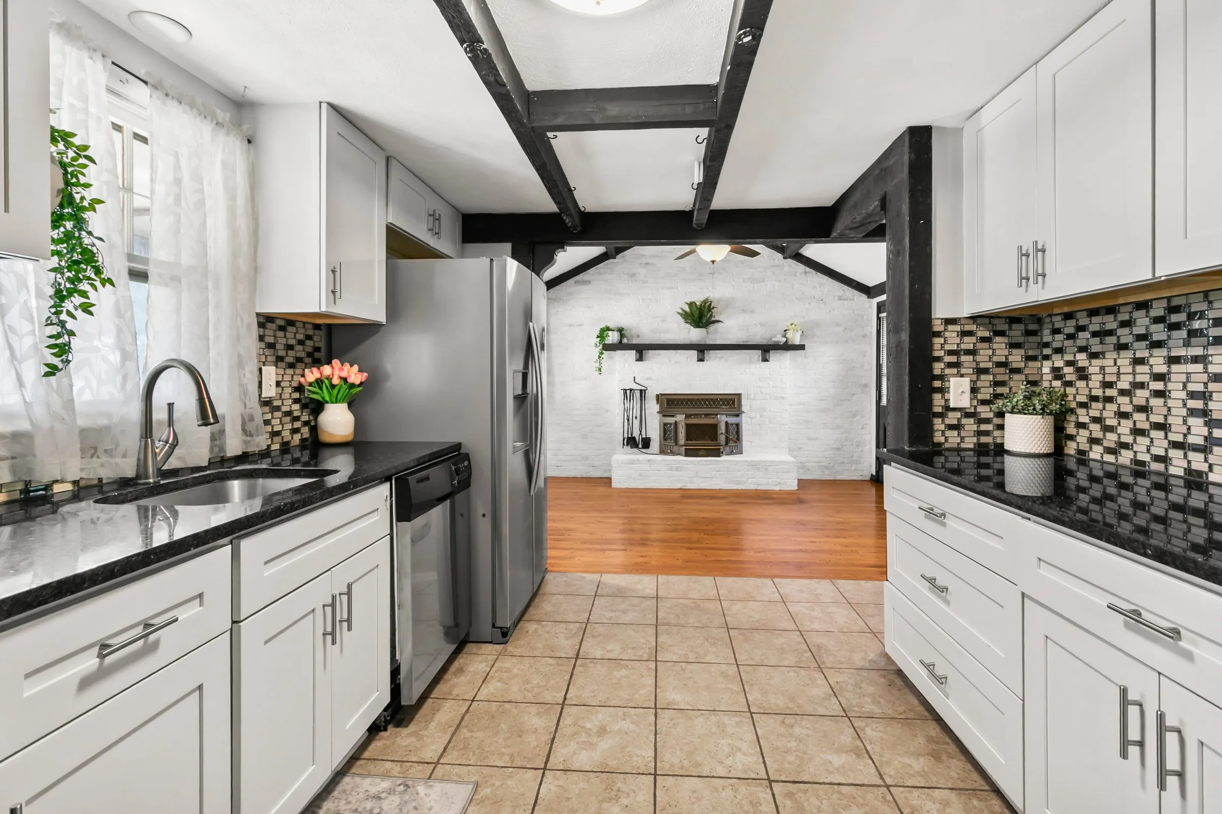 White kitchen with black granite counters and mosaic backsplash