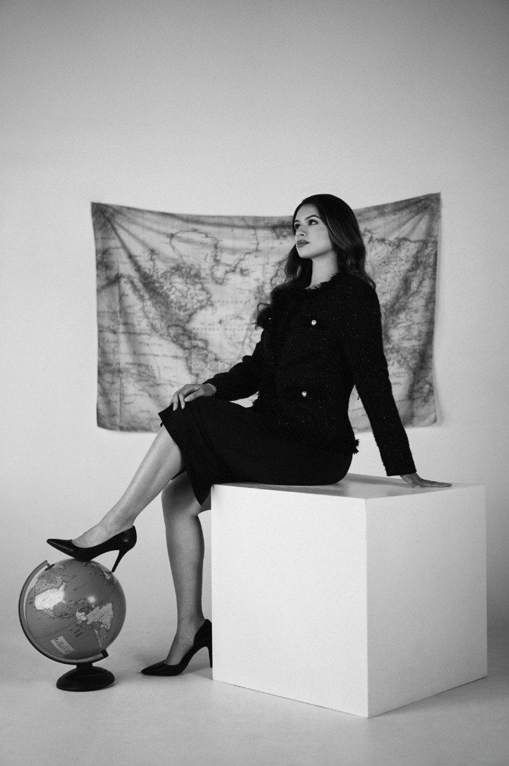 Frida seated beside a globe
